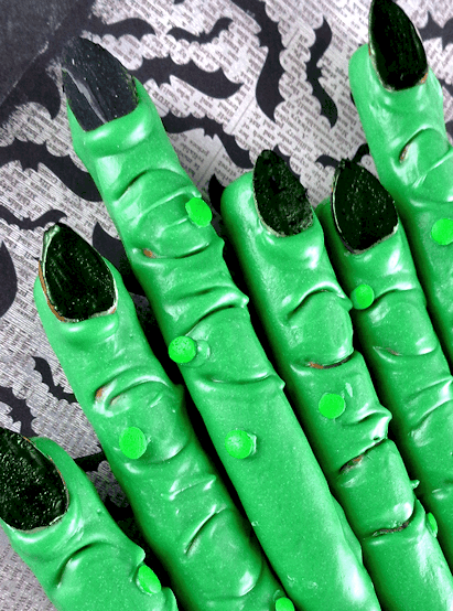 green pretzel rods decorated to look like witch fingers