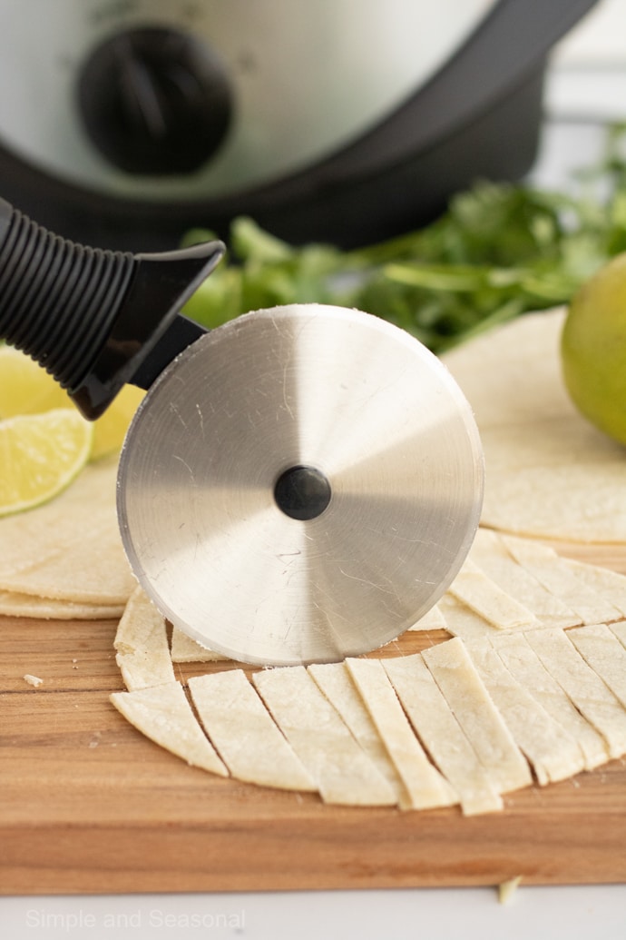 pizza cutter slicing tortillas into strips