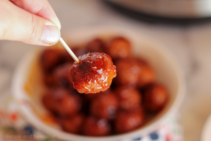 hand holding meatball skewered on a toothpick