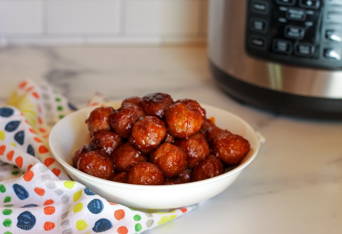 meatballs in a bowl on the counter with crockpot express in the corner