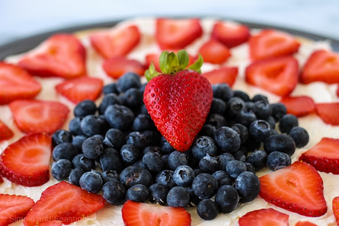 strawberry sitting on a pile of blueberries