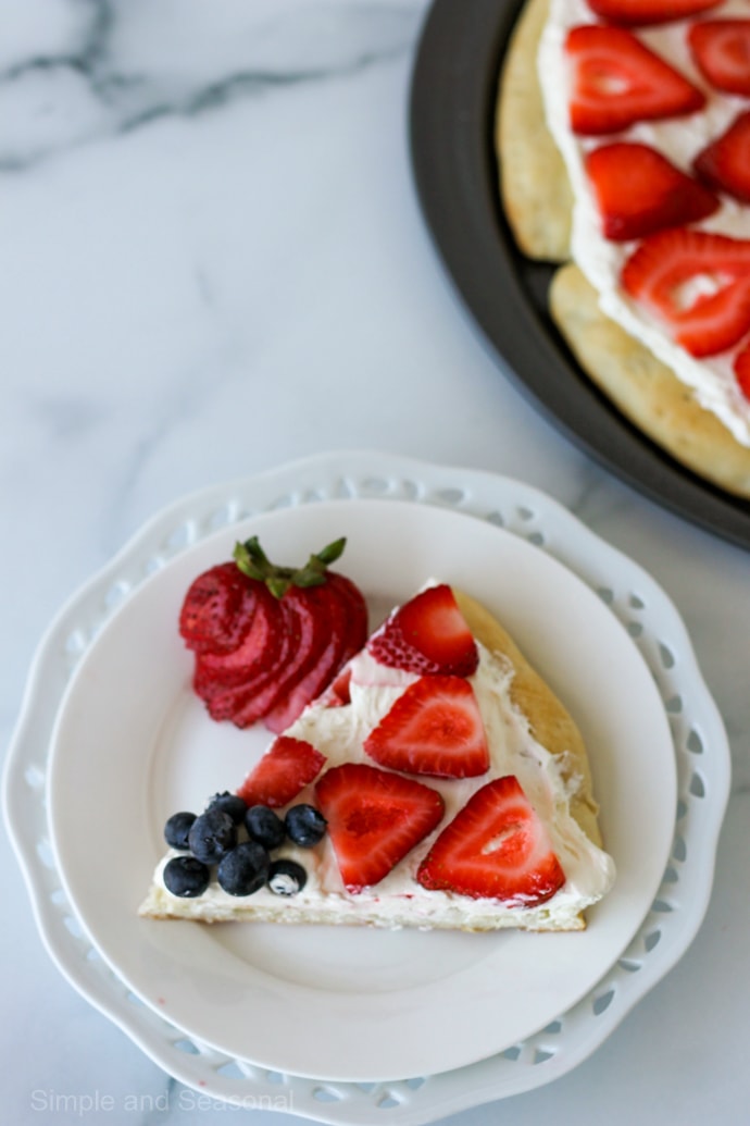 top down view of a slice of fruit pizza with strawberries and blueberries