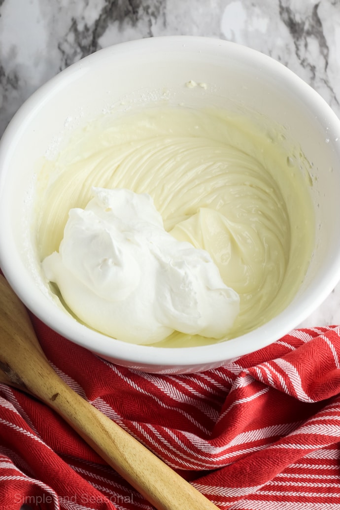 white bowl with mixed batter and dollop of whipped cream inside