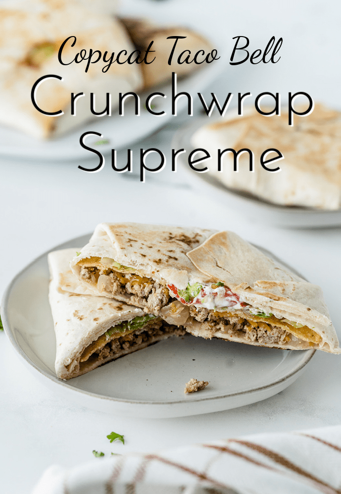 Copycat Crunchwrap Supreme sliced in half showing insides on a white plate