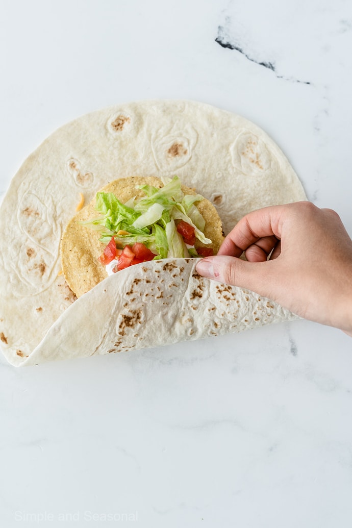 folding process to wrap large tortilla around crunchy shell in the center