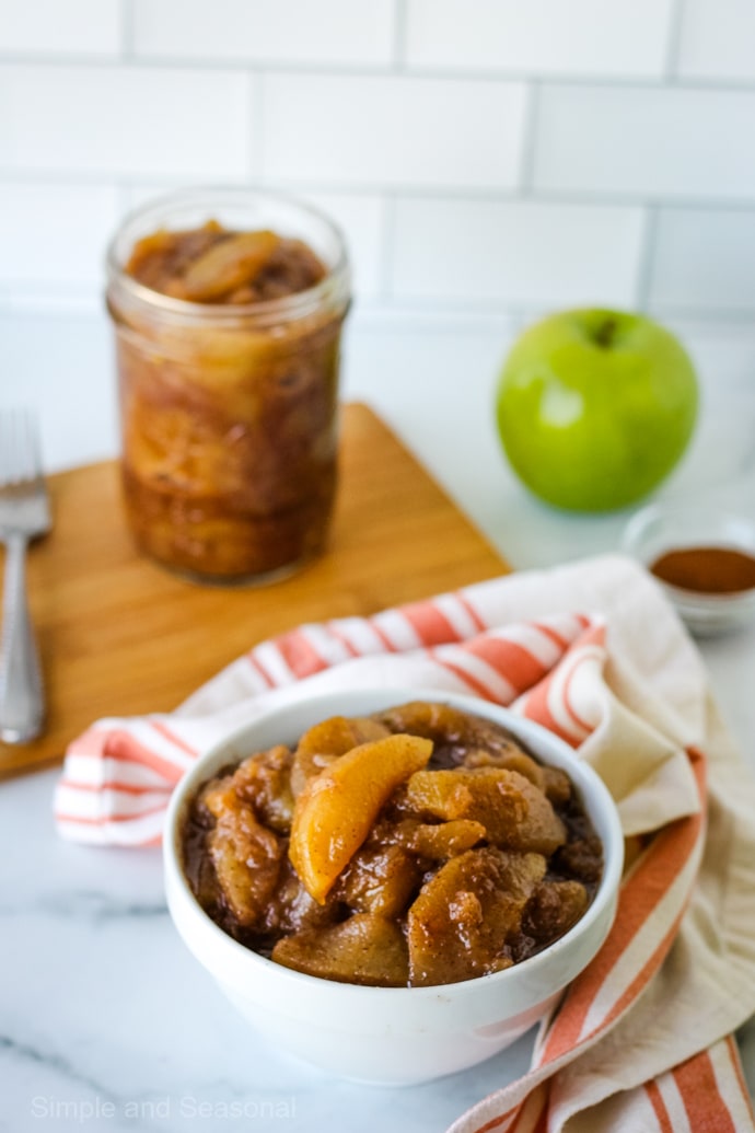 bowl of crockpot express apple pie filling with jar in the background