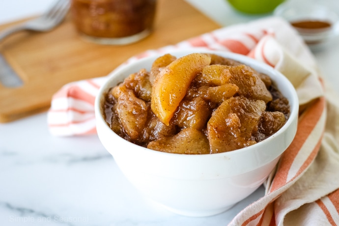 apple pie filling in a white bowl with a striped towel