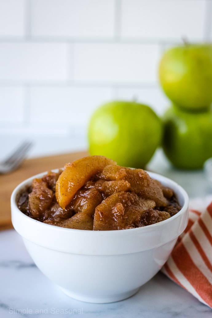 apple pie filling in a white bowl (closeup on apple slice)