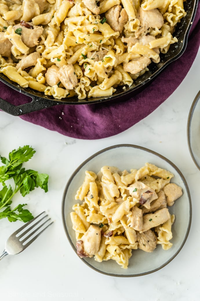 plate of chicken bacon pasta with skillet in the background