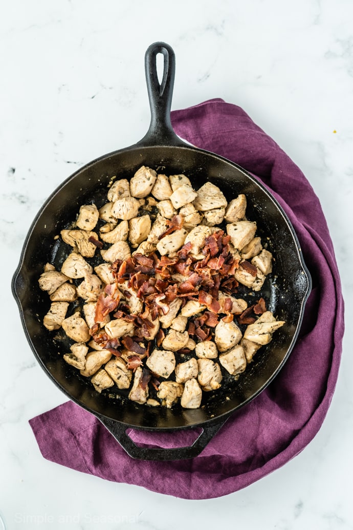 cooked chicken and bacon in a cast iron skillet