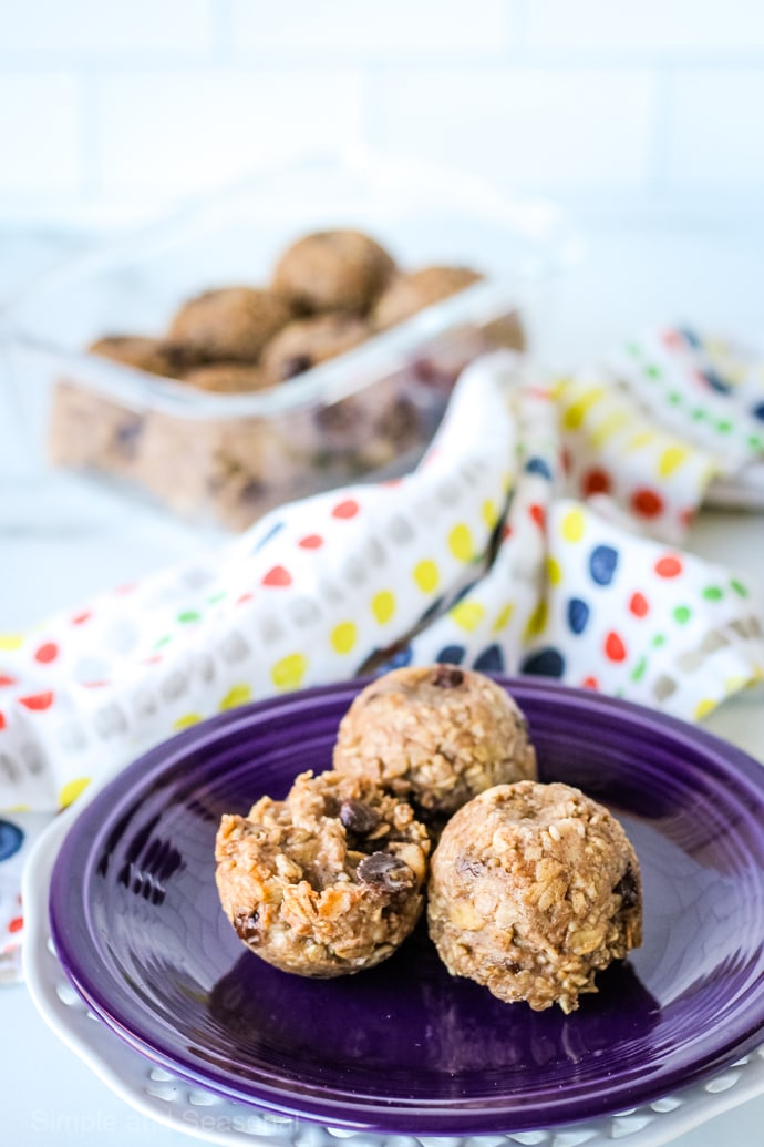 3 oatmeal bites on a plate with a glass container holding 6 bites in the background