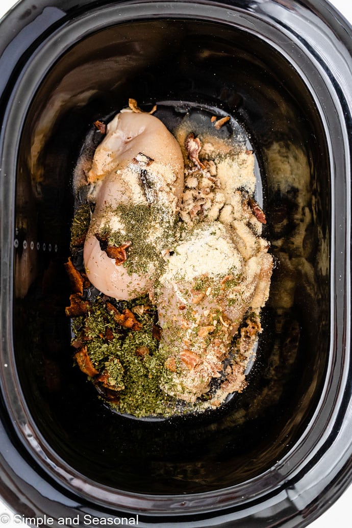 raw chicken, bacon and seasonings in the slow cooker