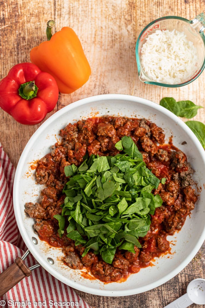 beef mixture with sauce and spinach in bowl