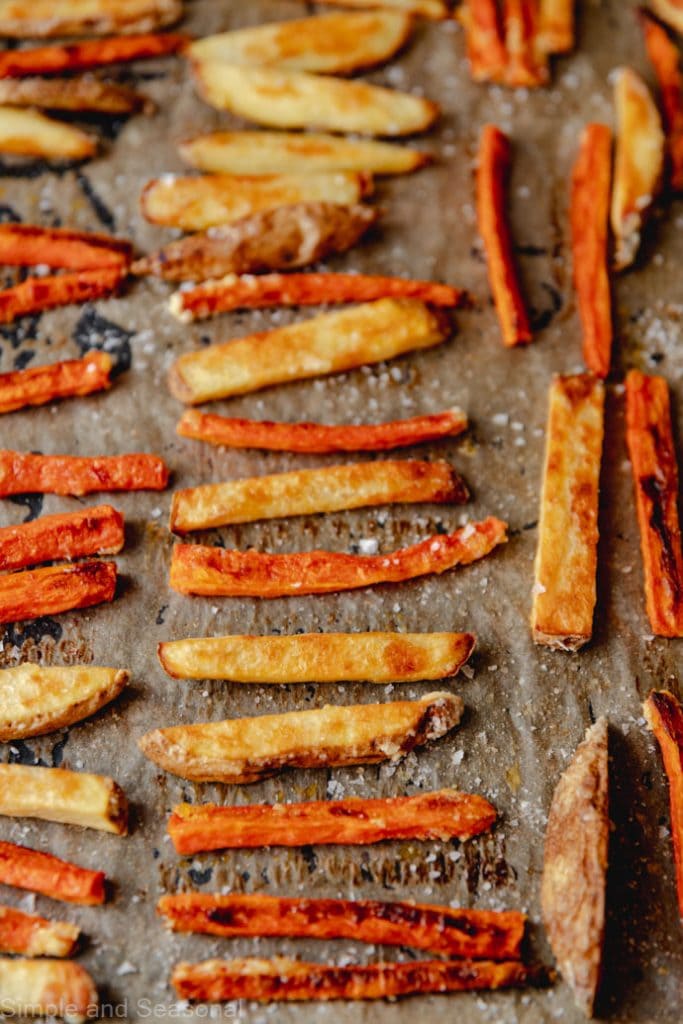 baked carrot fries and potato fries on a baking sheet