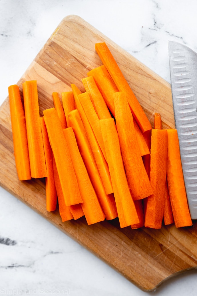 carrots cut into sticks on a cutting board