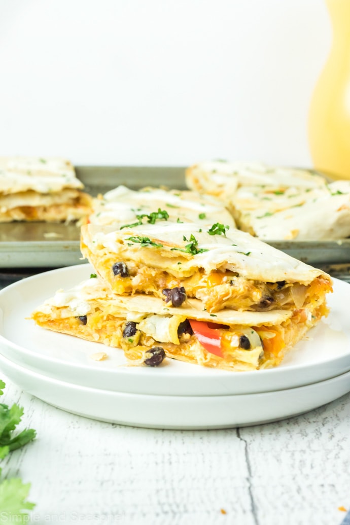 two quesadillas on a plate with the sheet pan in the background