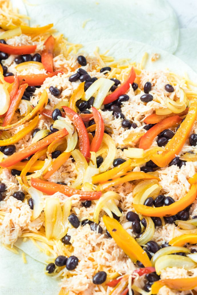 peppers and onions on top of the chicken mixture