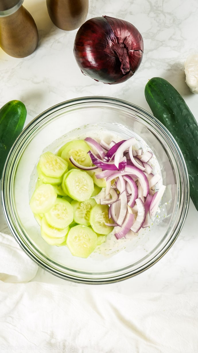 cucumber and onion in a bowl with creamy mixture