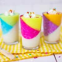 multicolored birthday cake jello cups on a colorful yellow napkin