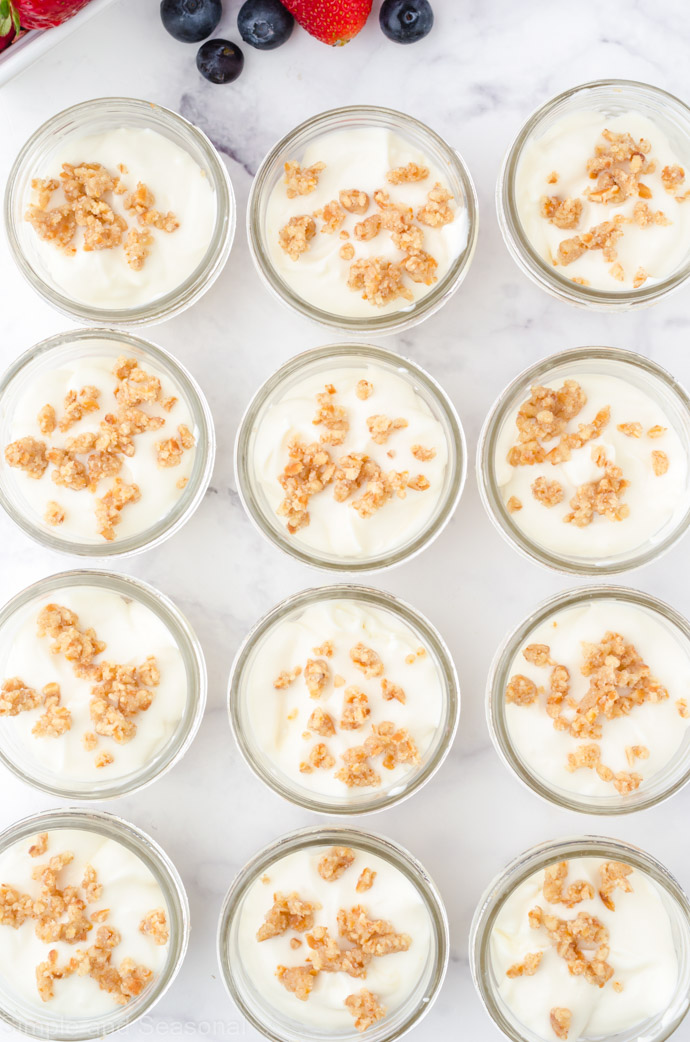 tray of mini mason jars filled with cheesecake filling and topped with pretzel crumbs