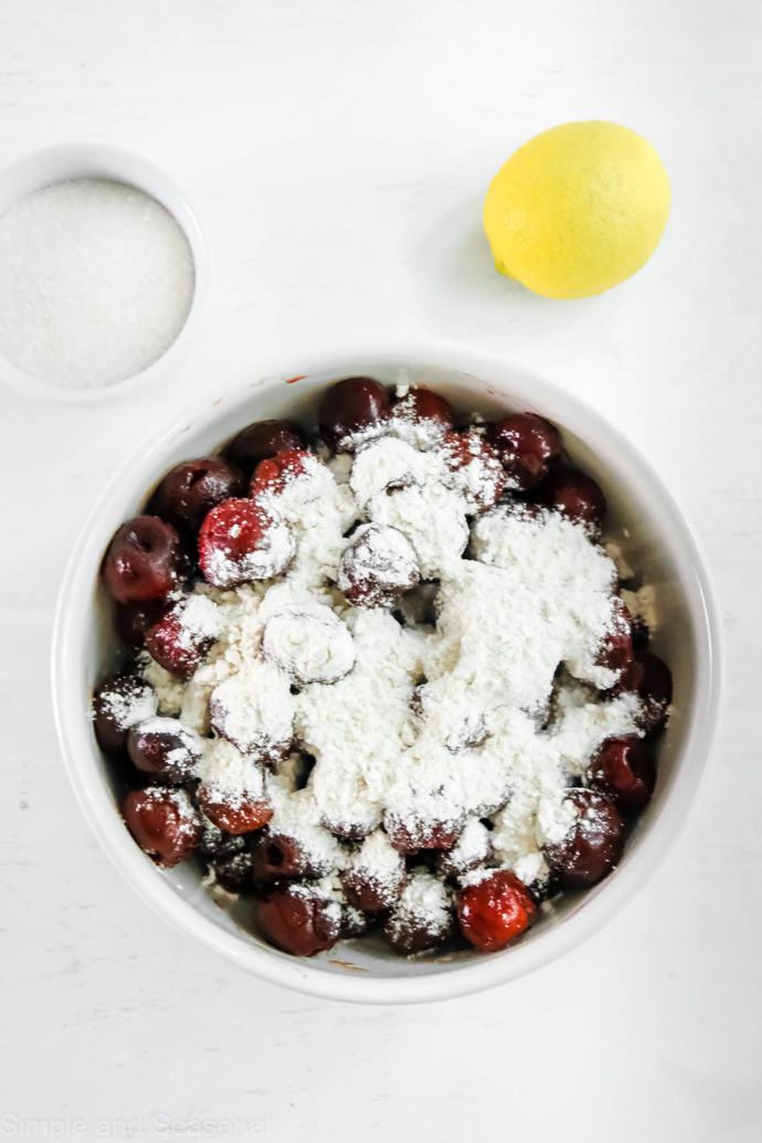 cherries in a bowl with flour, lemon juice and sugar