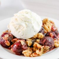 closeup of cherry crumble topped with ice cream