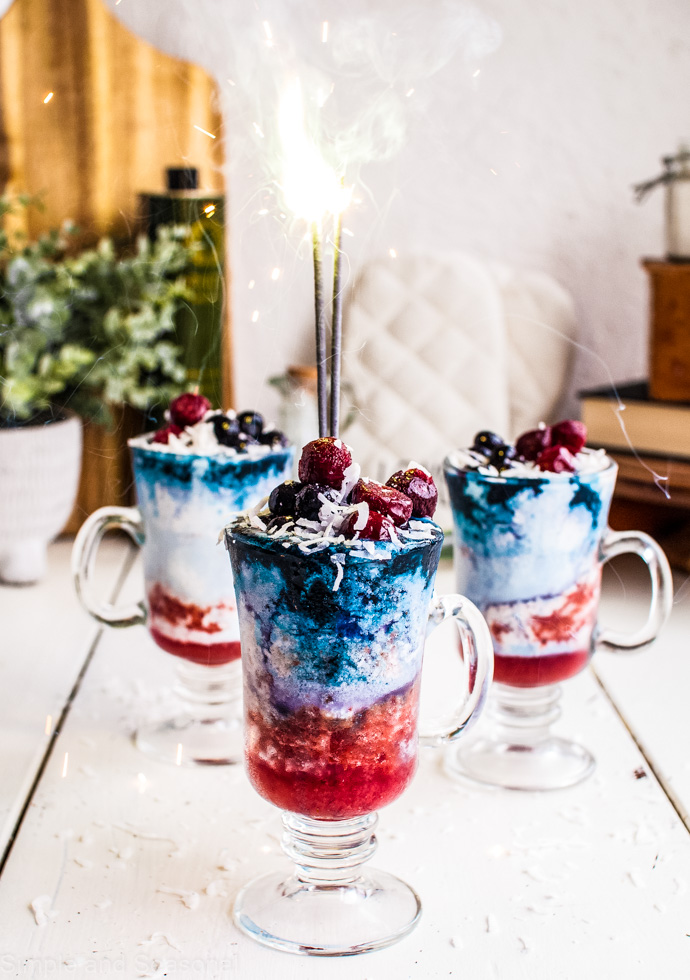 layered drinks with fresh fruit toppings and sparklers