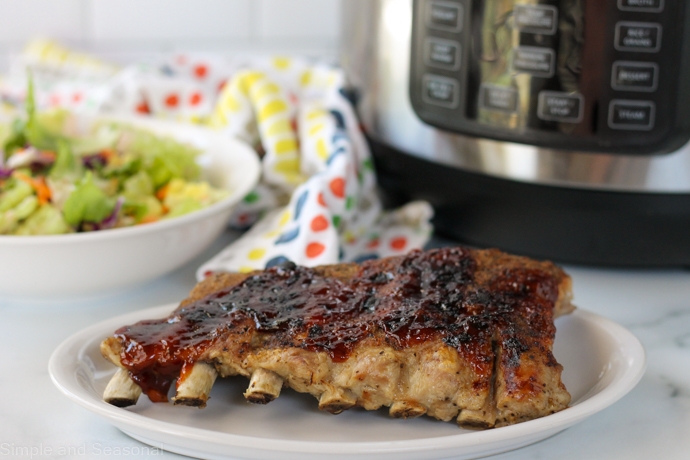 cooked rack of ribs with crockpot express in the background