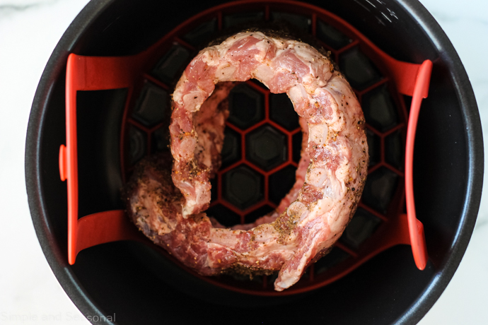 1 rack of ribs rubbed with spices and standing on end, curled into a circle inside the pot
