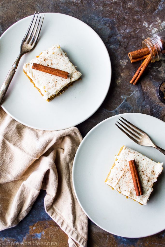 two plates with slices of pumpkin sheet cake on them