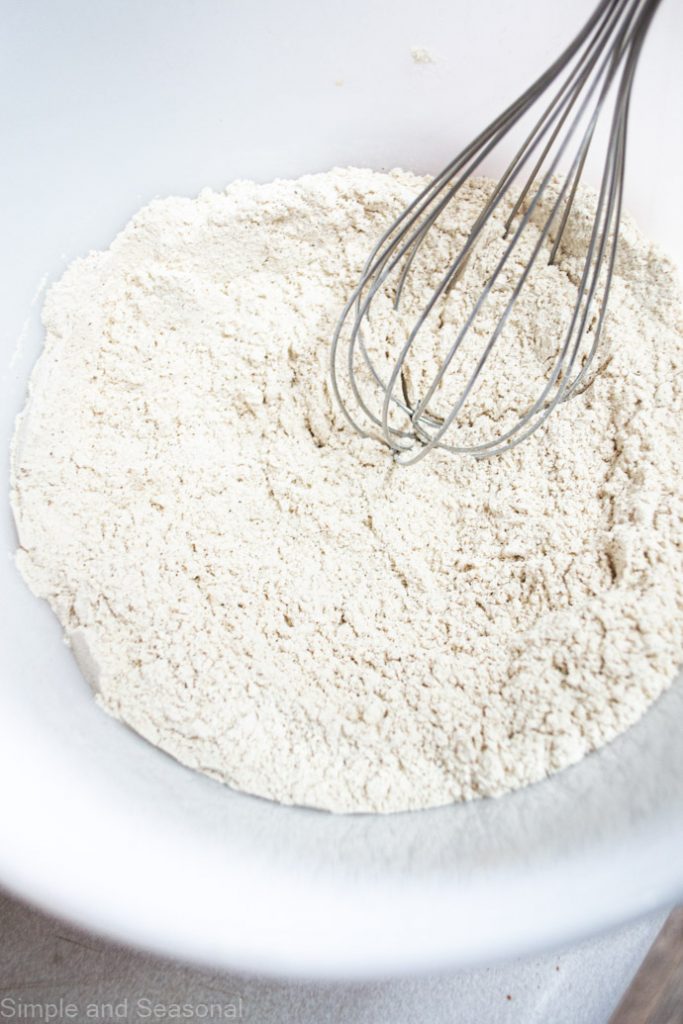 dry ingredients sifted together in a bowl with a whisk