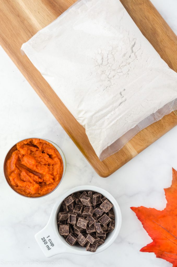 cake mix in the bag, pumpkin puree in a bowl and chocolate chunks in a bowl