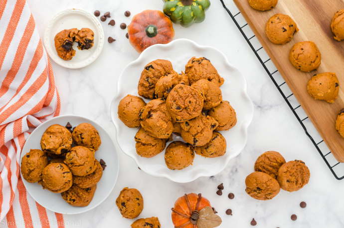 top down view of table with platter, plate and tray of pumpkin cookies