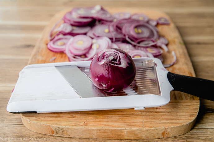 mandolin slicer with a red onion