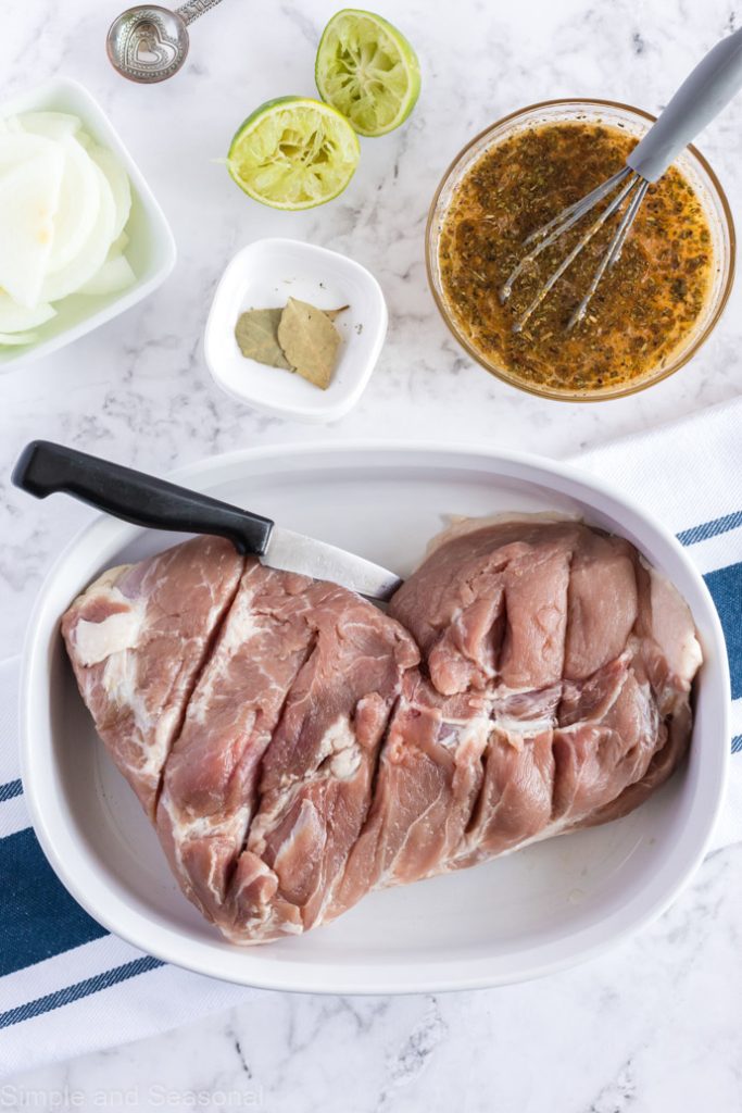 pork roast with paring knife in cooking dish