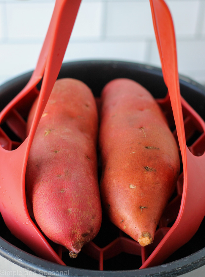 two sweet potatoes on a trivet with handles