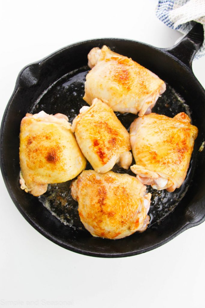 seared chicken thighs in a skillet