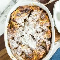 baked french toast in a casserole dish, dusted with powdered sugar