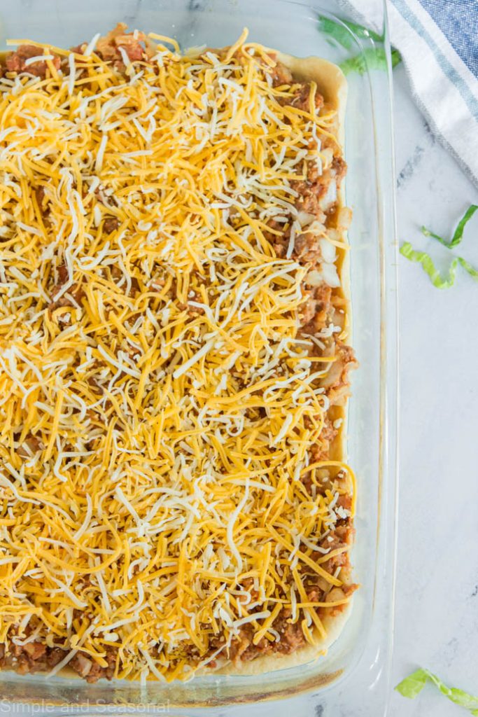 shredded cheese on top of meat mixture in pan