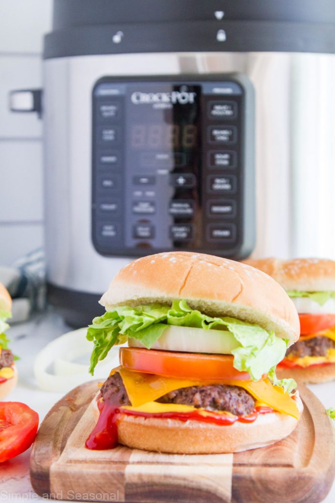 burger with dollop of ketchup oozing out the bottom with a Crockpot Express in the background