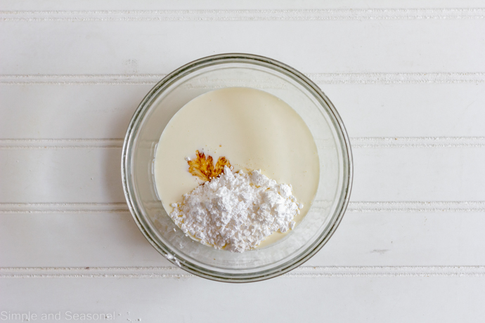 powdered sugar, vanilla and heavy cream in a bowl