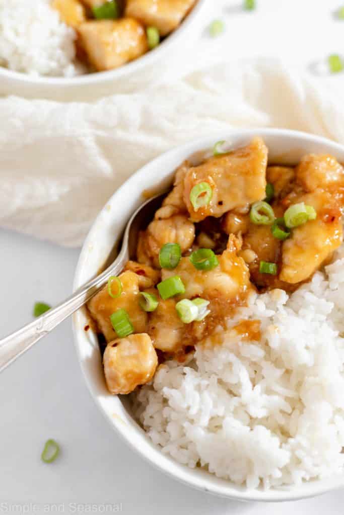 top down view of spoonful of red/orange chicken pieces