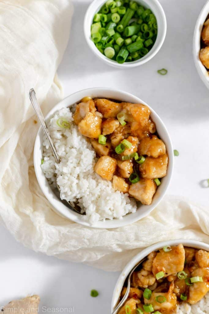 top down view of table with several bowls of spicy sweet chicken