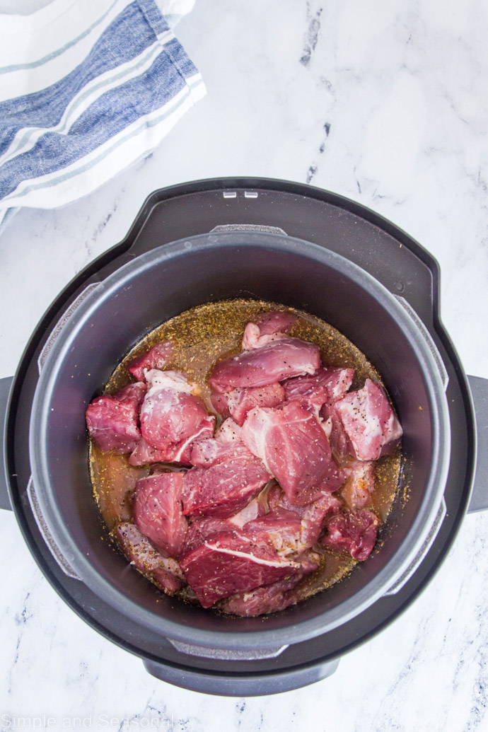 pork chunks and citrus marinade in cooking pot