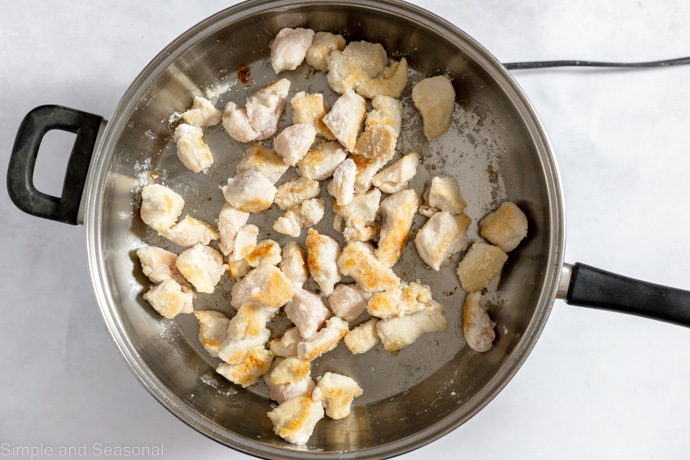 chicken browning in a skillet