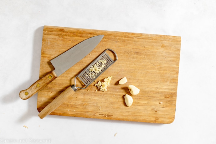 garlic cloves with knife and grater