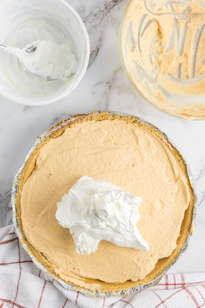 whipped topping being added as a third layer of pie
