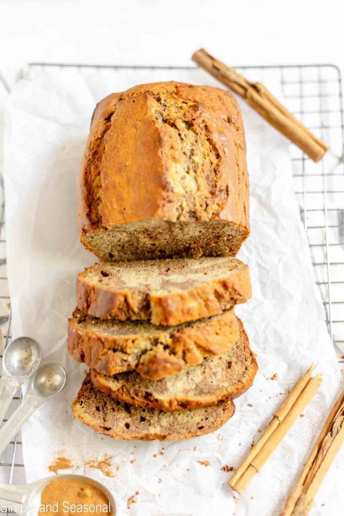 top down view of a loaf of banana bread with cinnamon sticks