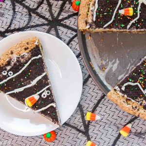 slice of cookie cake on a white plate with Halloween candies