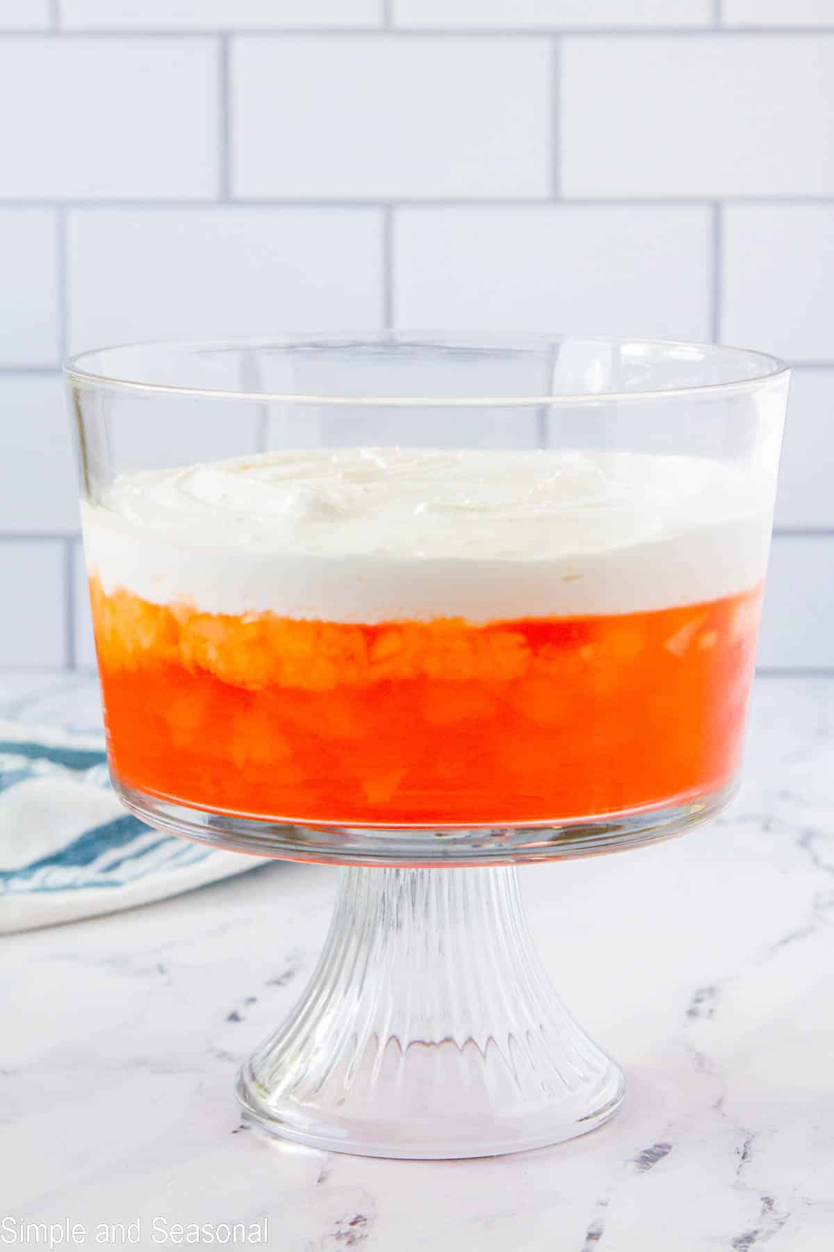 cream cheese and whipped topping layer on top of orange jello